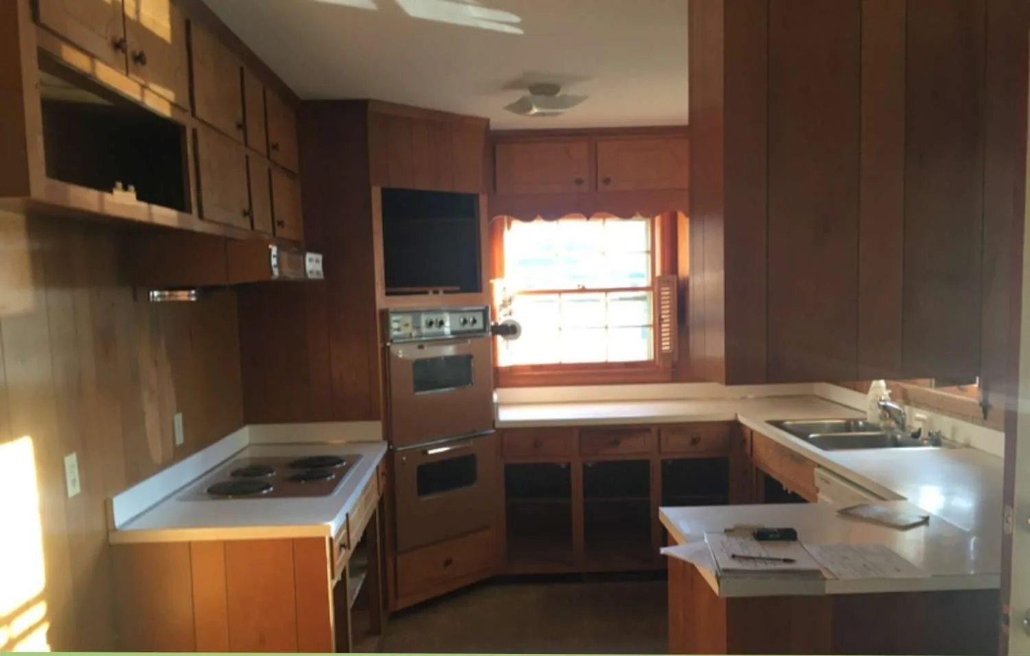 Kitchen before renovation, with dark wood cabinets and laminate counters
