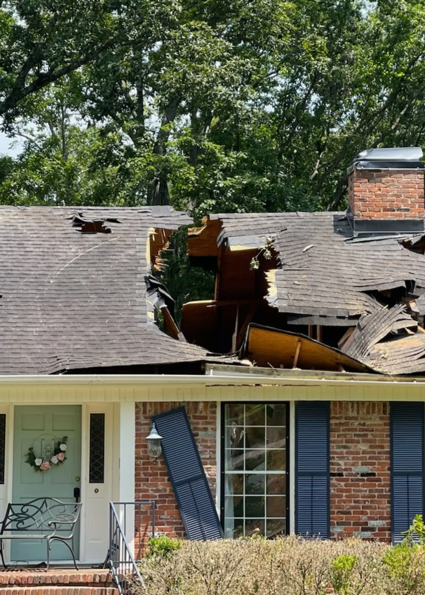 Storm damaged roof on a brick home in North Alabama, shingles and decking torn open