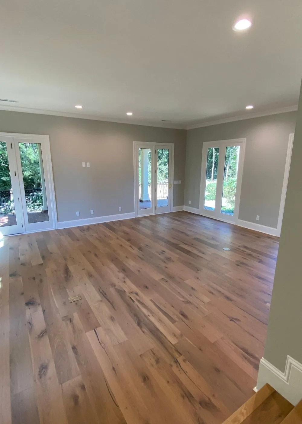 Open living space after a whole home renovation, with wide plank floors and new windows